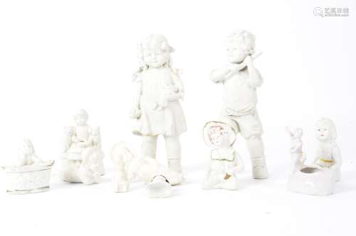 A group of predominantly bisque and white Victorian and later figures, including a half porcelain