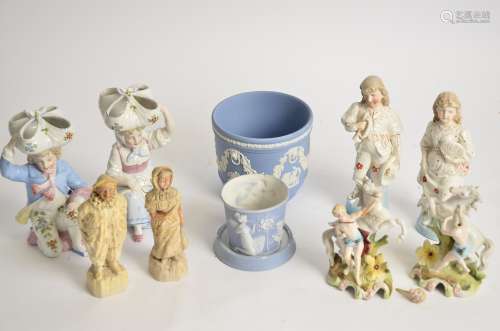 A small group of continental figures, to include a pair of kneeling figures supporting baskets on