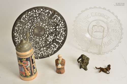 A cast metal charger with scrolling decoration and mythical figures, the reverse marked '