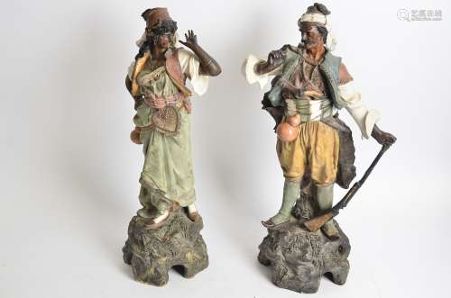 A pair of Goldscheider style painted terracotta statues of Ottoman type figures, one female, one