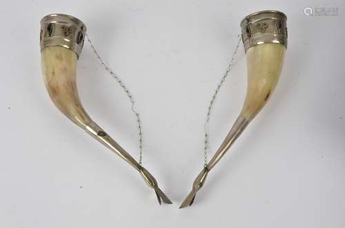 A pair of 20th Century ceremonial ox horn drinking cups, with silver plated mounts, and supported on