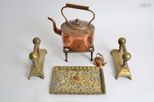 An early 20th Century copper kettle, a trivet, pair of brass firedogs and an repousse brass tray