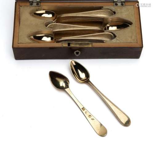 A wooden box with eighteen silver gilt teaspoons
