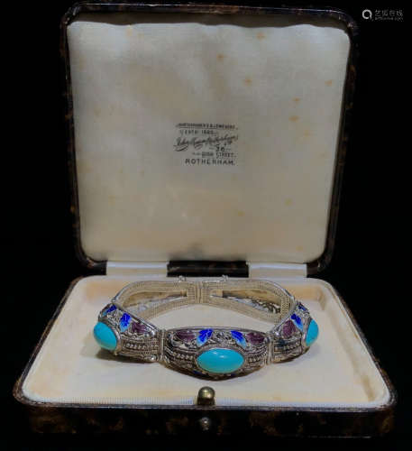 A SILVER BANGLE EMBEDDED WITH TURQUOISE