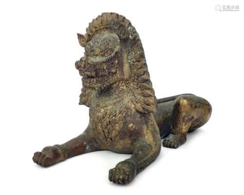 AN EASTERN GILDED BRONZE MODEL OF A STYLISED LION