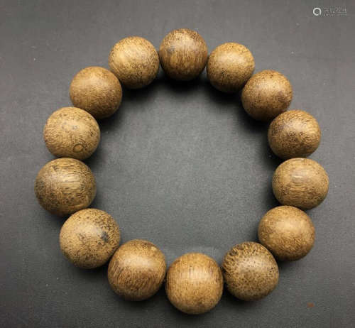 A CHENXIANG WOOD STRING BRACELET WITH 14 BEADS