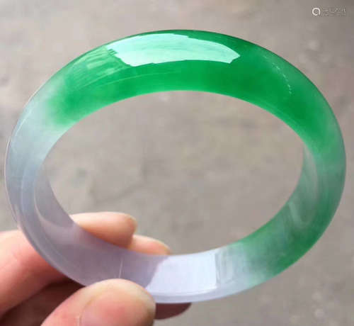 AN ICEY JADEITE CARVED BANGLE