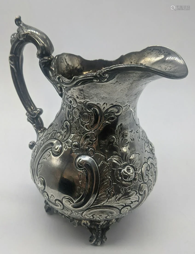 A silver milk jug, repousse embossed, vacant c…