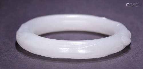 A HETIAN JADE BANGLE CARVED WITH WRAPPED FLOWER