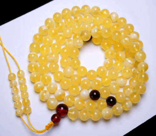 AN AMBER STRING NECKLACE WITH 108 BEADS