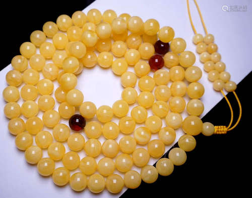 AN AMBER STRING NECKLACE WITH 108 BEADS