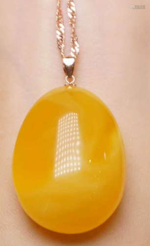 AN AMBER CARVED PENDANT