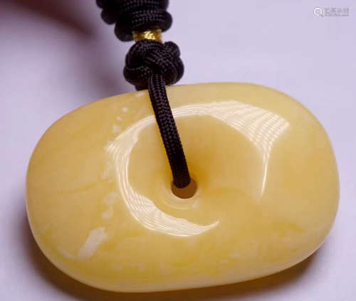 AN AMBER CARVED PENDANT