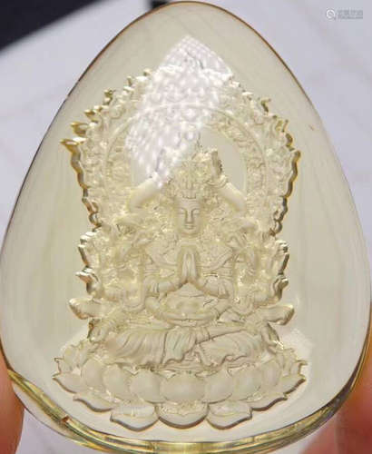 AN AMBER CARVED BUDDHA PATTERN PENDANT