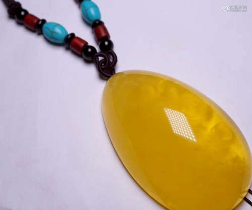 AN AMBER CARVED PENDANT