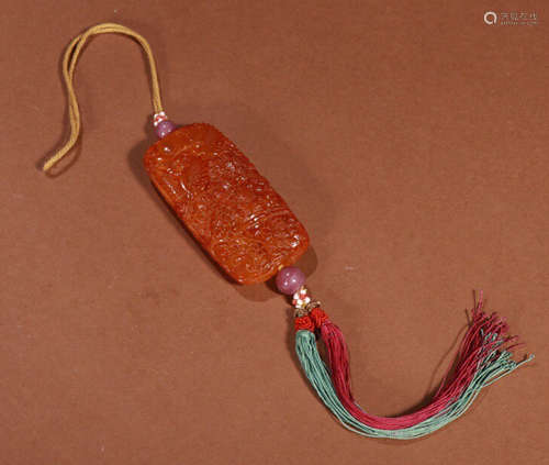 AN AMBER CARVED BEAD PENDANT