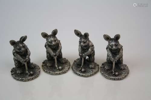 Set of four miniature figures in the form of rabbits playing golf.