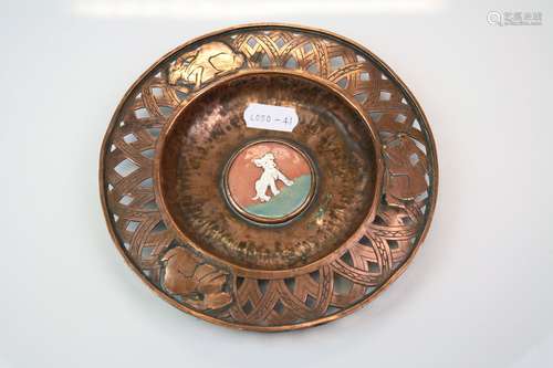 An arts & Crafts copper pin dish with pierced decorative rim and enamel dog to centre.