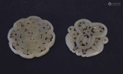 Two jade medallions with carving, one with fish, one with geometric designs (2)