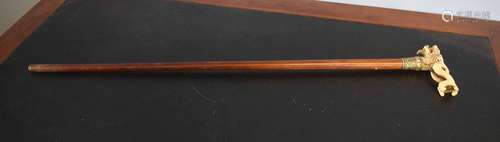 Malacca cane applied with a bone or ivorine handle formed as a temple dog with a ball in its