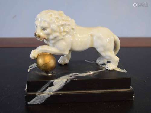 European model of a lion with a gilded ball resting underneath its front left foot, together with