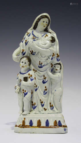 A Prattware pearlware figure representing Charity, circa 1790, decorated in ochre, brown and blue,