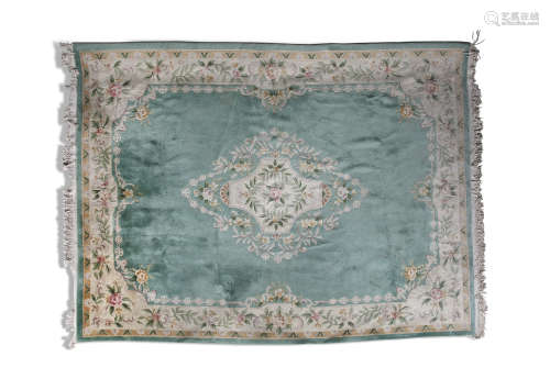 A CHINESE TEAL GROUND WOOL CARPET, with central floral medallion and broad cream borders. 380 x