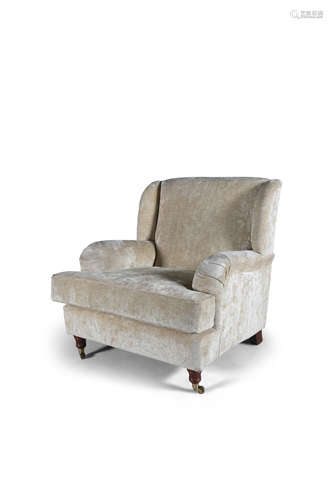 A MODERN HOWARD STYLE ARMCHAIR, upholstered in cream modern fabric, raised on turned front