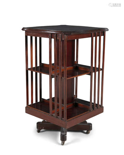 AN EDWARDIAN MAHOGANY TWO TIER REVOLVING BOOKCASE, of squared form, with wavy rim over compartmented