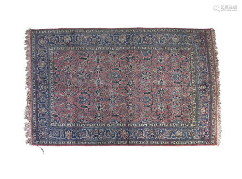 A SEMI ANTIQUE PERSIAN CARPET, the central reserve filled with flower heads and leafy sprays against