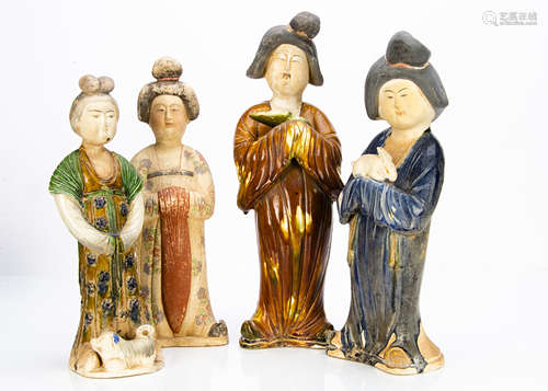 Four Chinese earthenware female tomb figures, in the Tang dynasty style, modelled standing, one with