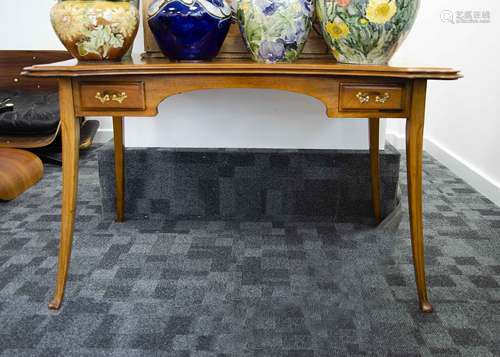 An Art Nouveau walnut desk, the top with whiplash design and brass three leaf clover fitted