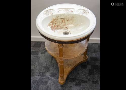 An Edwardian wash basin, the pottery circular top in an Aesthetic design decorated with birds within