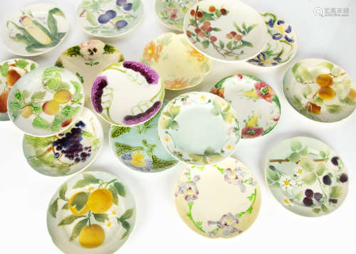 A collection of St Clement and Sarreguemines majolica plates, including a set of ten fruit and