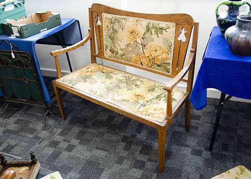 An oak Art Nouveau settle, the two seater settle with shaped back, pierced stylised floral backsplat