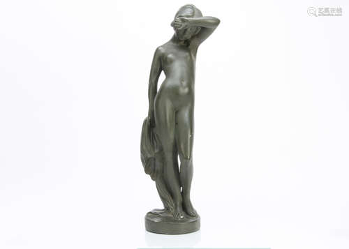 An Art Nouveau plaster figure of a young nude woman awakening, standing with one arm raised