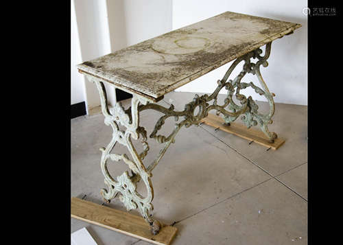 A marble topped garden table, the rectangular marble top supported on a cast iron frame of bracket