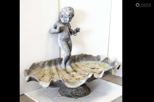 A 19th Century lead bird bath, modelled as a large conch shell with classical cherub standing