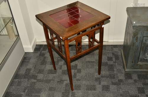 An Arts and Crafts tile top occasional table, the central red tiles surrounded by a large flange