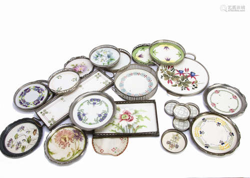 A collection of early 20th Century pottery and base metal Art Nouveau decorated coasters, teapot