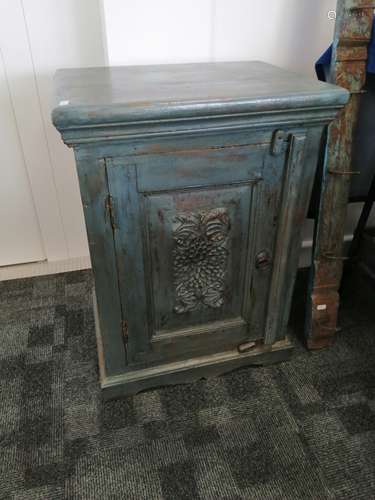 A continental blue painted cabinet, the hinged door with stylised floral carved decoration opening