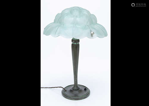 A continental Art Deco bronze and frosted glass table lamp, the circular base supporting a faceted