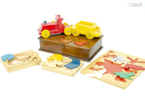 A wooden child's carpet train, by Escor, in red and yellow together with various wooden puzzles