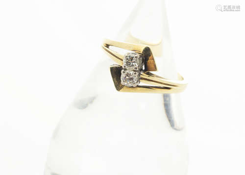 A 14ct gold diamond set crossover dress ring, the brilliant cuts in four claw setting on yellow gold