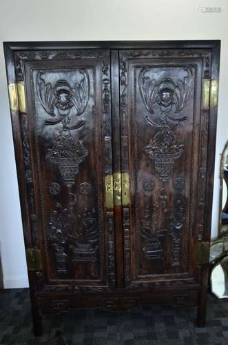 A Chinese hardwood 20th Century linen cabinet, with pair of panelled doors carved with bats