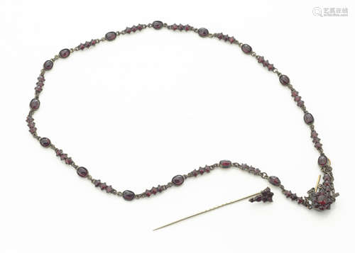 An early 20th Century foil backed continental garnet necklace, oval and circular faceted in claw and