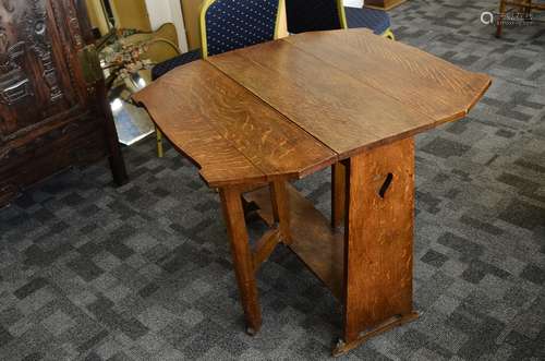 An oak Arts an Crafts drop leaf table, the block side panels with pierced heart design supporting