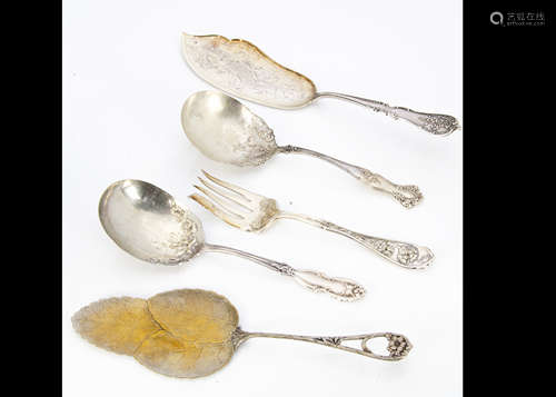 A collection of silver plated and white metal serving implements, including asparagus forks, fish