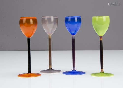 A set of four continental harlequin coloured Vaseline liquor glasses, in orange, green, blue and