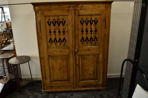 A continental waxed pine kitchen cabinet, Scandinavian, the double panel doors with stylised heart